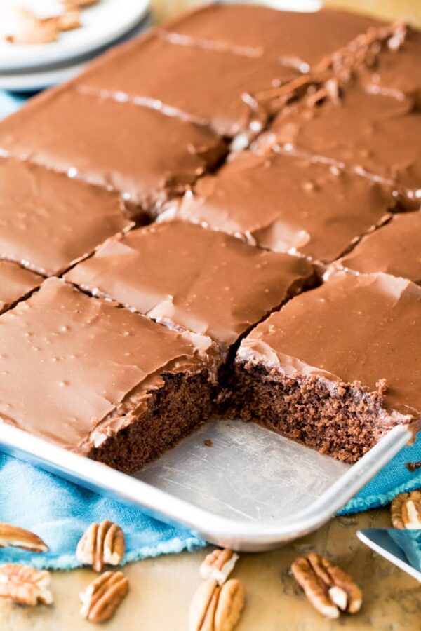 A pan of brownies with chocolate frosting and pecans.