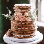 A stack of cookies on top of a Tiered Cakes.