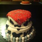 A cake decorated with a cowboy bandana and pearls.