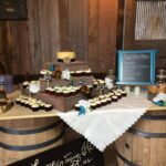 A table with cupcakes and cupcakes on top of barrels.