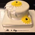 A white cake with yellow flowers on it.