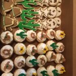 A box of cookies decorated with cactus and stars.