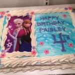 A frozen birthday cake with a picture of elsa and anna.