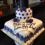 A square cake with a graduation hat on top.