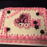 A pink cake with a skateboard on it.