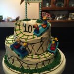 A cake with a lego race track on top.