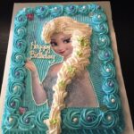 A frozen birthday cake with elsa's face on it.