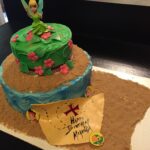 A cake with a tinker bell on top.