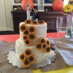 A wedding cake with sunflowers on top.