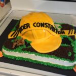 A cake with a construction hat on it.