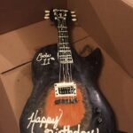 A cake that looks like a guitar.