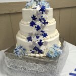 A white and blue wedding cake on a table.