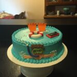 A cake decorated with a swimming pool and a cell phone.