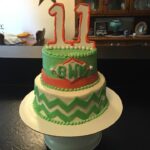 A green and orange cake with the number 11 on it.