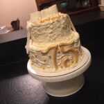 A white cake with the number 75 on it.