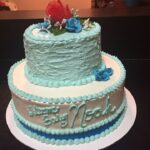 A blue and white cake with roses on top.