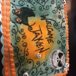 A cake with skeletons and jack-o-lanterns on it.