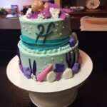 A cake decorated with seashells and mermaids.