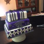 A purple and black cake on top of a counter.