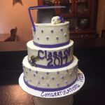 A three tier cake with a graduation hat on it.