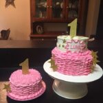 A pink cake with a gold star on top.