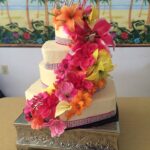 A three tier cake decorated with colorful flowers.