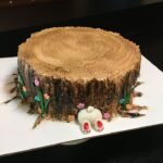 A cake decorated like a tree stump.