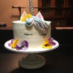 A unicorn cake with flowers on top.