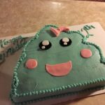 A birthday cake with a poop face on it.