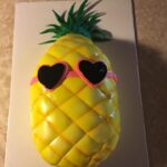 A pineapple cake with sunglasses on it.