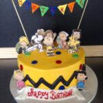 A birthday cake decorated with charlie brown and his friends.