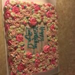 A birthday cake with pink and blue flowers on it.