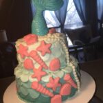 A cake with a mermaid tail on top.