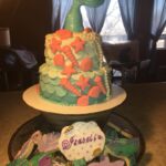 A cake with a mermaid tail and cookies.