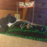 A cake with a monster truck on top of it.