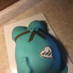 A blue cake with a teddy bear on it.