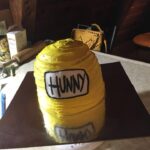 A yellow cake with the word hunny on it.