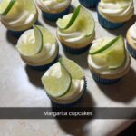 A group of cupcakes with lime slices on top.