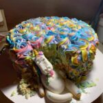 A cake with a unicorn on top of it.