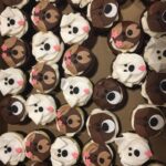 A box of cupcakes decorated with dog faces.