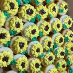 A box of cupcakes decorated with sunflowers.