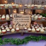 Cupcakes on a wooden stand with a sign that says once in a while.