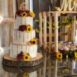 A wedding cake with sunflowers on top.