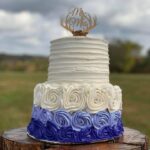 A blue and white wedding cake with a deer on top.