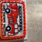 A cake with a fire truck on it.