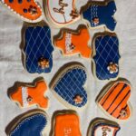 A group of orange and blue decorated cookies on a table.