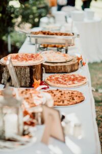 A long table with pizzas on it.