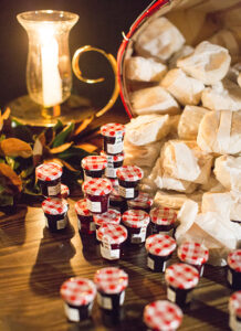 A basket of jelly cups on a table next to a candle.